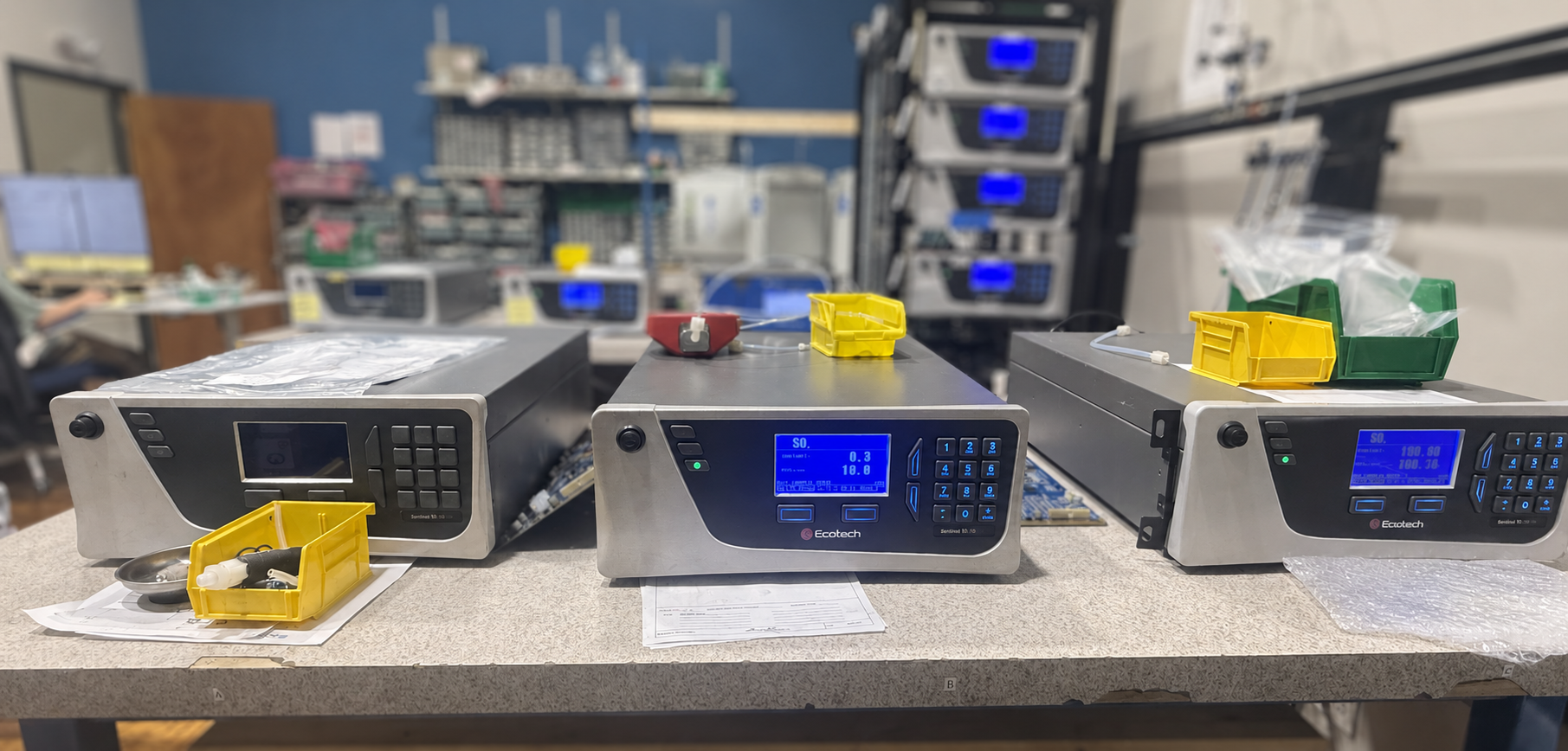 Lab bench with a row of Ecotech gas analyzer instruments